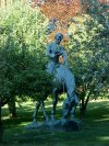 Statue of Abraham Lincoln reading a book, on a horse which is chomping grass