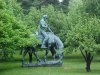 Statue of Abraham Lincoln reading a book, on a horse which is chomping grass