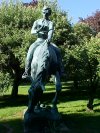 Statue of Abraham Lincoln reading a book, on a horse which is chomping grass