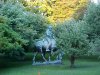 Statue of Abraham Lincoln reading a book, on a horse which is chomping grass