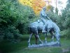 Statue of Abraham Lincoln reading a book, on a horse which is chomping grass
