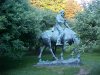 Statue of Abraham Lincoln reading a book, on a horse which is chomping grass