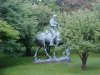 Statue of Abraham Lincoln reading a book, on a horse which is chomping grass