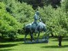 Statue of Abraham Lincoln reading a book, on a horse which is chomping grass