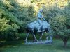 Statue of Abraham Lincoln reading a book, on a horse which is chomping grass