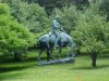 Statue of Abraham Lincoln reading a book, on a horse which is chomping grass