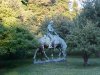 Statue of Abraham Lincoln reading a book, on a horse which is chomping grass