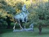 Statue of Abraham Lincoln reading a book, on a horse which is chomping grass